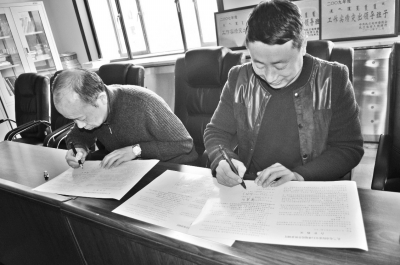 内蒙古扎兰屯市农民正在与当地农技推广中心工作人员签订轮作协议。王岭岭 刘宝君 摄