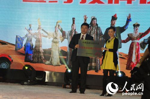 中景品联COO陈小花女士向达拉特旗授予“中国旅游品牌示范基地”牌匾