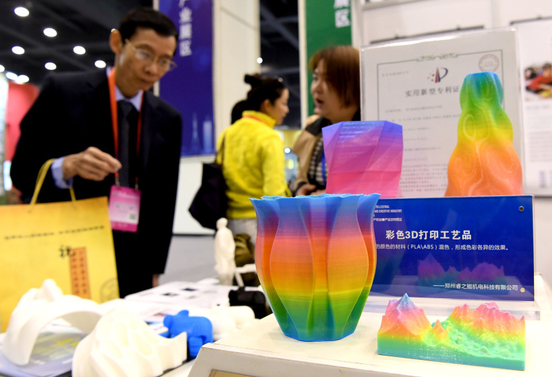 3月29日，参会客商在了解参观一款3D打印设备。